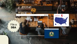 A look from above on a men and a woman sitting at a desk to file a DBA in Vermont